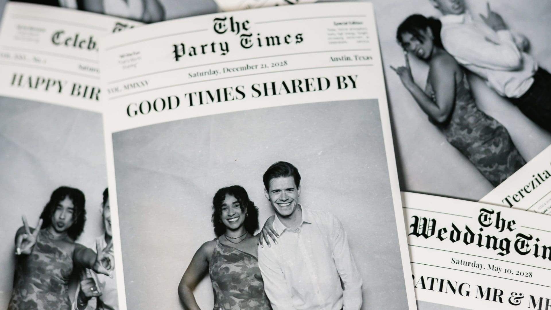 Stack of personalized newspaper-style party invitations featuring photos of a smiling couple.